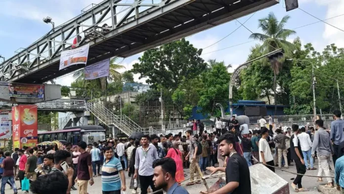 বন্যা পরিস্থিতির মধ্যে পরীক্ষা নেওয়া এবং প্রশ্নপত্রে ভুল ও শিক্ষার্থীদের ‘ফার্মের মুরগি’ বলার প্রতিবাদে শিক্ষামন্ত্রীর পদত্যাগ চেয়ে আজ সারা দিন ঢাকাসহ দেশের বিভিন্ন স্থানে আন্দোলন করছেন শিক্ষার্থীরা। বিজ্ঞাপন এ প্রসঙ্গে জাতীয় সংসদে এক প্রশ্নের জবাবে শিক্ষামন্ত্রী ড. আ ন ম এহছানুল হক মিলন বলেছেন, যেসব কেন্দ্রে ভুলত্রুটি বা সমস্যা হয়েছে, সেখানে পুনরায় পরীক্ষা নেওয়ার আইনি সুযোগ রয়েছে। তিনি শিক্ষার্থীদের পড়ার টেবিলে ফিরে যাওয়ার অনুরোধ জানিয়েছেন। তিনি বলেছেন, শিক্ষার্থীদের চেয়েও সরকার তাদের পরীক্ষা সঠিকভাবে নেওয়া এবং দুর্যোগ মোকাবিলা করার বিষয়ে বেশি উদ্বিগ্ন। মঙ্গলবার (১৪ জুলাই) জাতীয় সংসদের অধিবেশনে নির্ধারিত প্রশ্নোত্তর পর্বে সংসদ সদস্য শফিকুল ইসলাম মাসুদের এক সম্পূরক প্রশ্নের জবাবে শিক্ষামন্ত্রী এসব কথা বলেন। ডেপুটি স্পিকার ব্যারিস্টার কায়সার কামালের সভাপতিত্বে এদিনের সংসদ অধিবেশন শুরু হয়। বিজ্ঞাপন সংসদে পরীক্ষা নিয়ে সৃষ্ট অসন্তোষ ও শিক্ষার্থীদের ক্ষোভ প্রশমনে সরকারের উদ্যোগ সম্পর্কে জানতে চাওয়া হলে শিক্ষামন্ত্রী জানান, বর্ষা মৌসুমে পরীক্ষা নেওয়া নিয়ে সরকার নিজেও বেশ চিন্তিত। সংশ্লিষ্ট দপ্তরগুলো থেকে আবহাওয়া অনুকূলে থাকবে- এমন পূর্বাভাস পাওয়ার কারণেই মূলত পরীক্ষা চালু রাখার সিদ্ধান্ত নেওয়া হয়েছিল। তবে উদ্ভূত পরিস্থিতি সামাল দিতে শিক্ষা মন্ত্রণালয় সার্বক্ষণিক মনিটরিং ব্যবস্থা চালু রেখেছে। পরীক্ষা চলাকালীন দেশের কোনো কেন্দ্রে পানি ওঠার খবর পাওয়া মাত্রই স্থানীয় প্রশাসনের সহযোগিতায় তাৎক্ষণিকভাবে বিকল্প কেন্দ্রে পরীক্ষা নেওয়ার ব্যবস্থা করা হয়েছে। কুমিল্লাসহ দেশের বিভিন্ন অঞ্চলের পরীক্ষা কেন্দ্রের পরিস্থিতি উল্লেখ করে শিক্ষামন্ত্রী বলেন, কিছু জায়গায় পানি উঠলেও তা দ্রুত সমাধান করা হয়েছে এবং পরীক্ষার্থীদের জন্য প্রয়োজনীয় সব ধরনের সুযোগ-সুবিধা নিশ্চিত করা হয়েছে। এরপরও যদি প্রশাসনের কোনো গাফিলতির কারণে শিক্ষার্থীরা পরীক্ষা দিতে না পেরে থাকে বা ক্ষতিগ্রস্ত হয়ে থাকে, তবে তথ্য যাচাই করে সেখানে পুনরায় পরীক্ষা নেওয়া হবে। মন্ত্রী স্পষ্ট জানিয়ে দেন যে সরকারের কাছে পর্যাপ্ত বিকল্প প্রশ্নপত্র প্রস্তুত রয়েছে। ইতোমধ্যে চট্টগ্রাম বোর্ডে পরিস্থিতি বিবেচনায় যেমন বিশেষ ব্যবস্থা নেওয়া হয়েছে, ঠিক তেমনি প্রয়োজনে যেকোনো ক্ষতিগ্রস্ত অঞ্চলের জন্য পুনরায় পরীক্ষা নেওয়ার অবস্থান সরকারের রয়েছে। শিক্ষার্থীদের আন্দোলনের পথ পরিহার করে পড়াশোনায় মনোযোগ দেওয়ার তাগিদ দিয়ে আ ন ম এহছানুল হক মিলন বলেন, শিক্ষার্থীরাই দেশের আগামী দিনের ভবিষ্যৎ। তাদের কোনোভাবেই অধিকার থেকে বঞ্চিত করা হবে না। যেকোনো প্রতিকূল পরিস্থিতি মোকাবিলায় প্রশাসন সর্বোচ্চ আন্তরিকতার সঙ্গে কাজ করছে এবং শিক্ষার্থীদের ক্ষতি পুষিয়ে দিতে সব ধরনের প্রয়োজনীয় ব্যবস্থা গ্রহণ করা হবে।